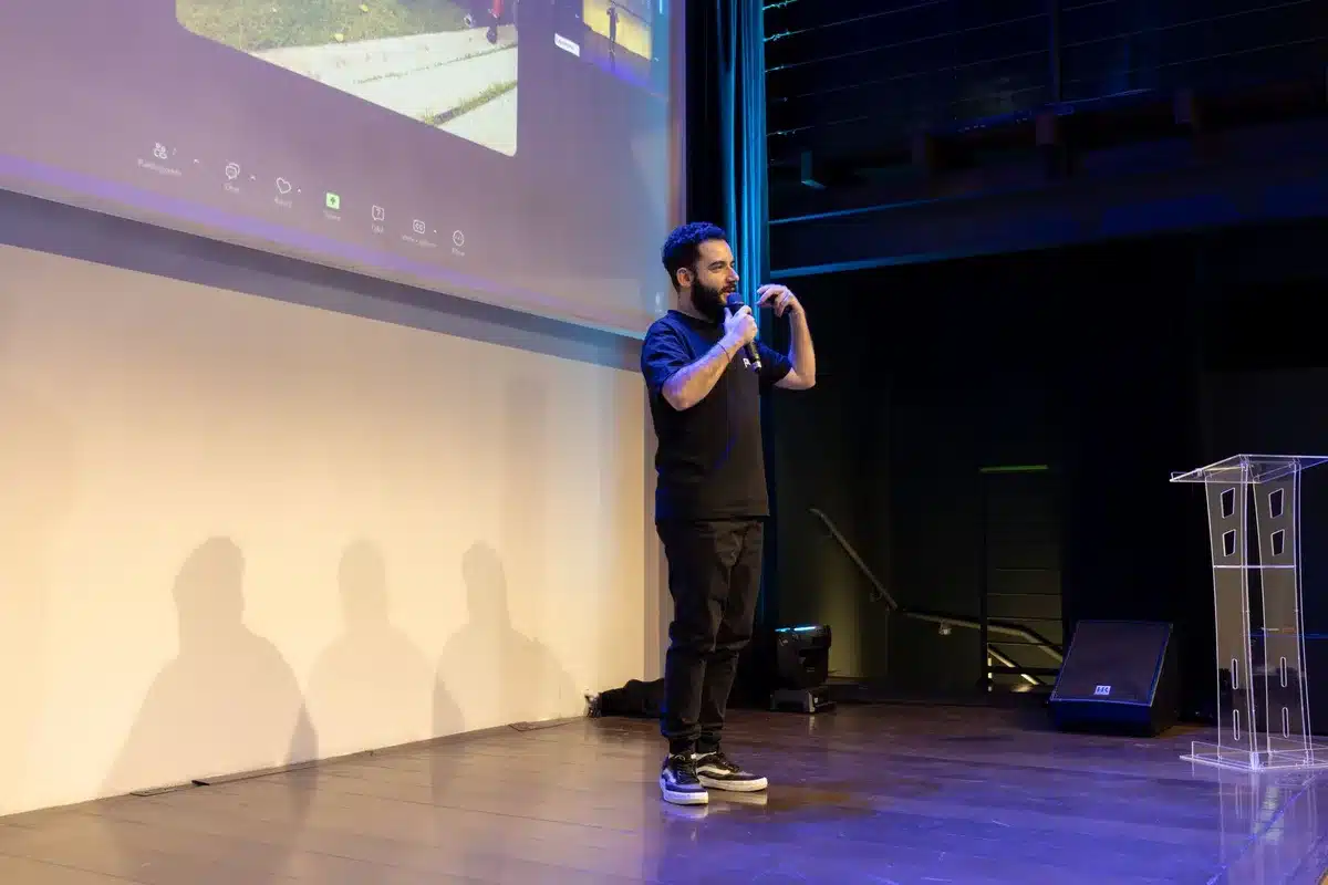 Gaming showcase presentation stage with audience and large display screens