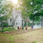 Glowing magical spells cast over a rural farm with creatures and crops under a mystical sky