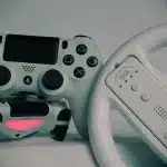 Gloved hand on stone map beside torch and retro game controller in a dim castle corridor