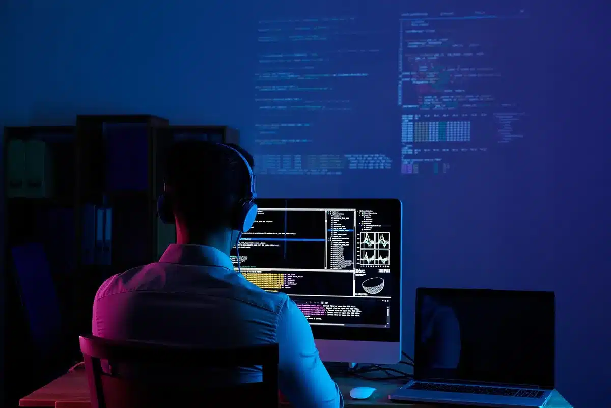 Silhouette of a woman at a computer in a game studio, contemplative